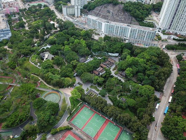 Aerial photo of a green landscaped park with paths, pavilions and sports courts, 2018.